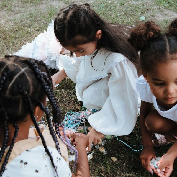 Group of diverse children sitting in a circle and smiling.